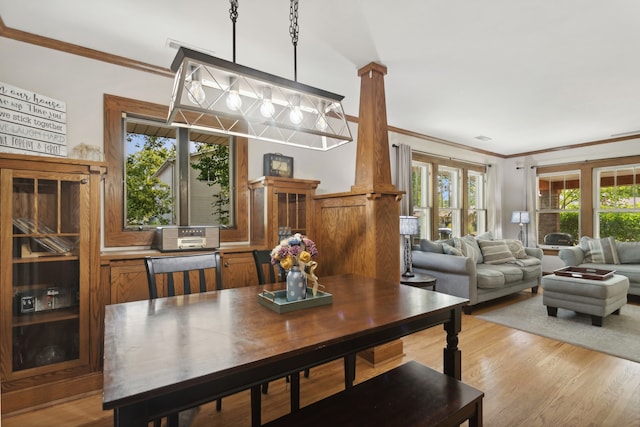 dining area with light wood-type flooring and crown molding