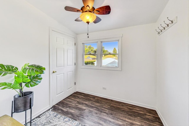 unfurnished bedroom with ceiling fan, baseboards, and dark wood-style flooring