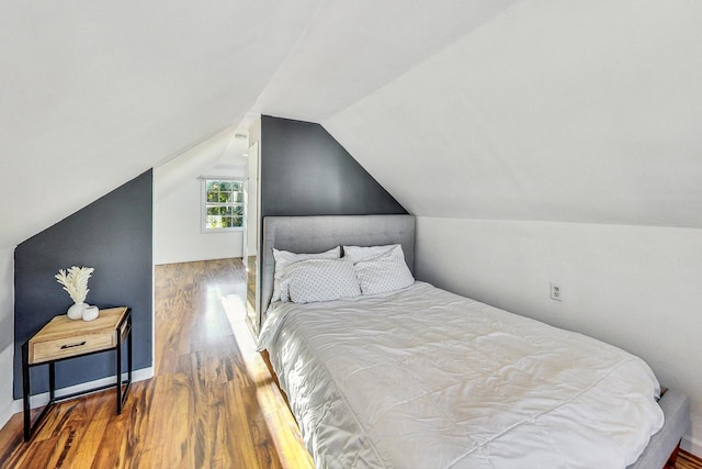 bedroom with hardwood / wood-style flooring and lofted ceiling