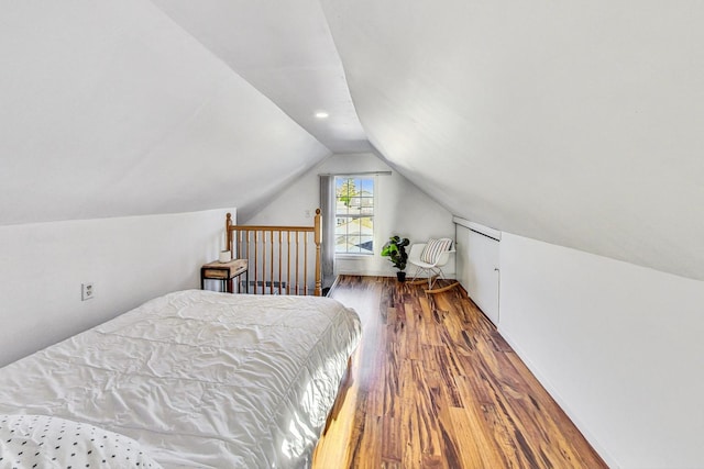 bedroom with vaulted ceiling and wood finished floors