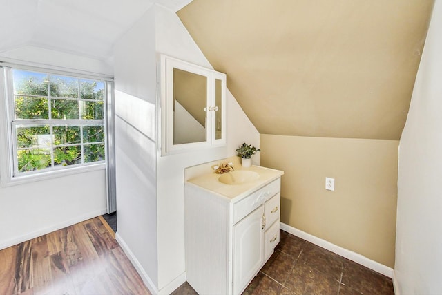 bathroom with wood-type flooring, vanity, and vaulted ceiling