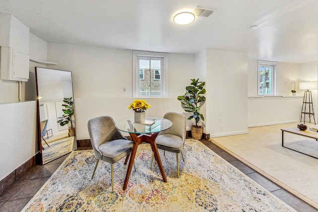 dining area with baseboards, dark tile patterned floors, and visible vents