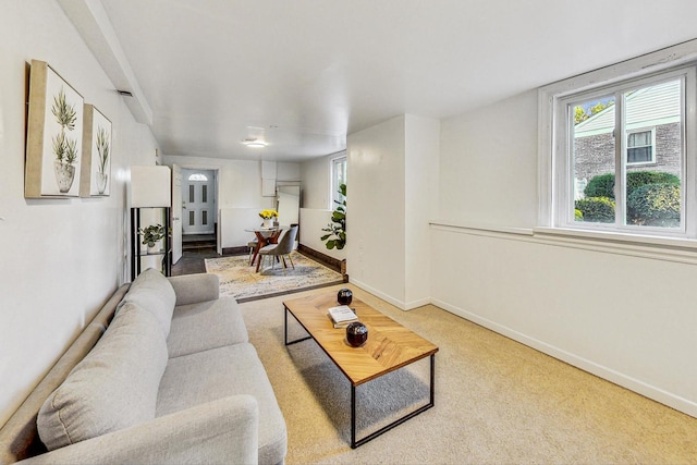 carpeted living area featuring baseboards