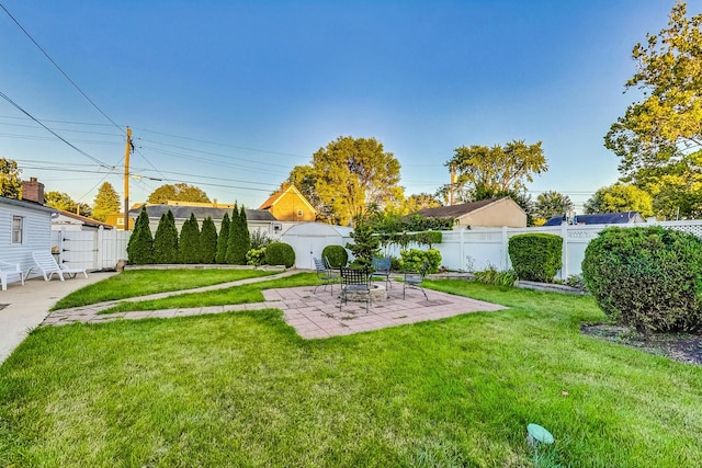 view of yard with an outdoor structure, a shed, a patio, and a fenced backyard