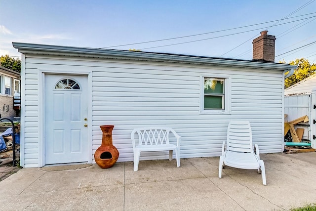 back of house with a chimney and a patio