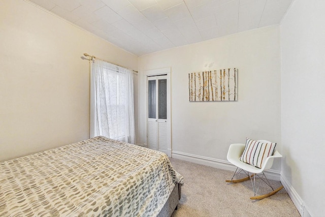 carpeted bedroom with a closet and crown molding