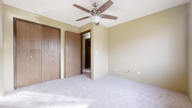 unfurnished bedroom with ceiling fan, light colored carpet, and a closet