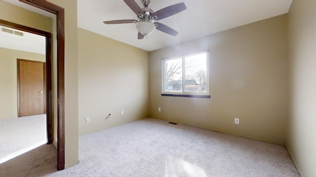 spare room with light colored carpet and ceiling fan