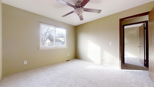 carpeted empty room featuring ceiling fan