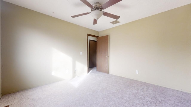 spare room with light colored carpet and ceiling fan