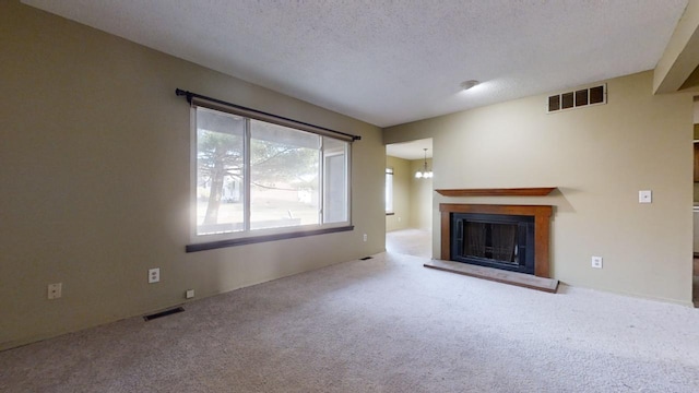 unfurnished living room featuring carpet and a textured ceiling