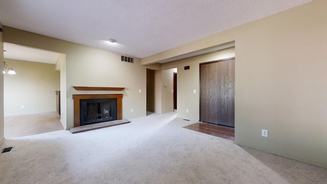 unfurnished living room with light carpet and a textured ceiling