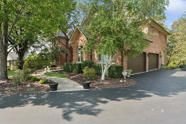 view of property hidden behind natural elements featuring a garage