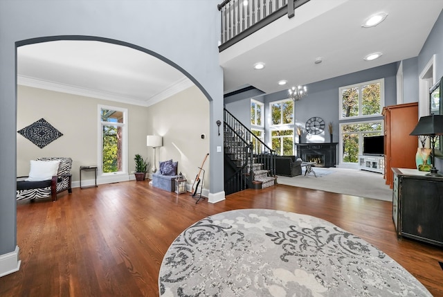 living room with hardwood / wood-style flooring, a chandelier, and ornamental molding