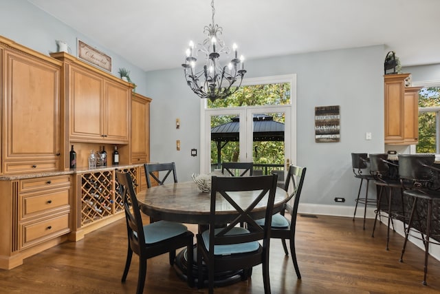 dining area with an inviting chandelier and dark hardwood / wood-style flooring