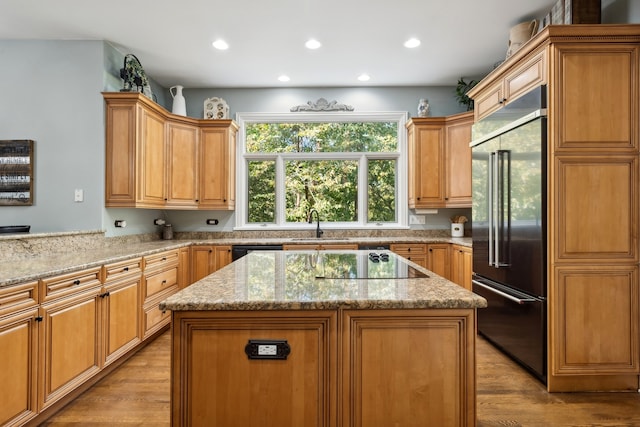 kitchen with light hardwood / wood-style floors, black appliances, and a kitchen island