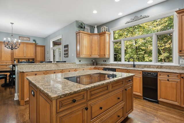 kitchen with sink, a kitchen island, decorative light fixtures, black electric cooktop, and hardwood / wood-style floors