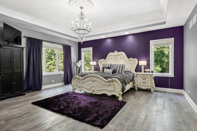 bedroom with crown molding, an inviting chandelier, a closet, and wood-type flooring