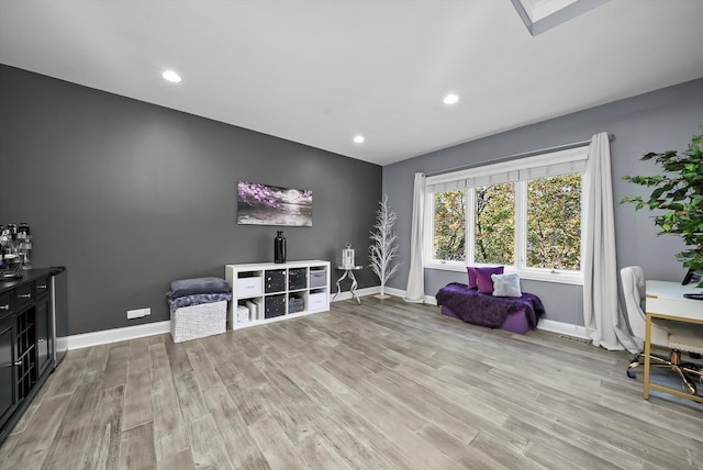 living area with a skylight and hardwood / wood-style flooring