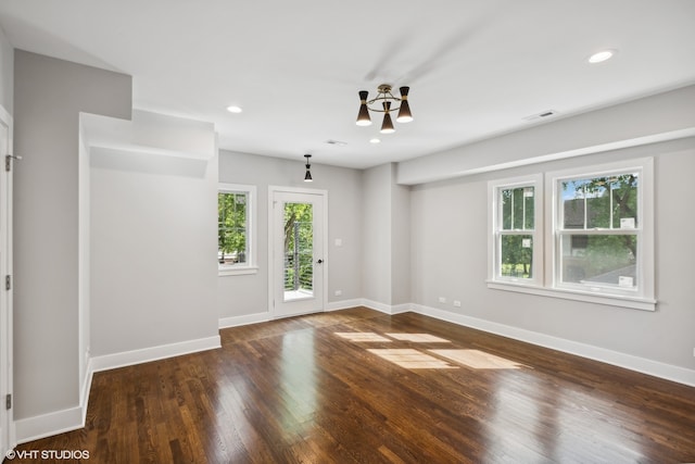 unfurnished room featuring dark hardwood / wood-style floors and a notable chandelier