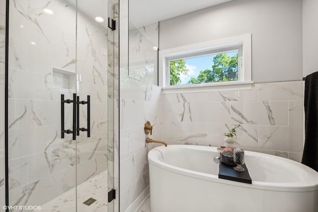 bathroom with tile walls and separate shower and tub