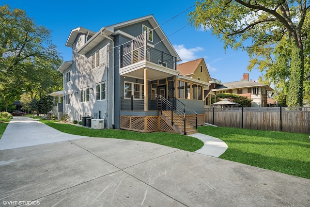 exterior space with a sunroom, a front lawn, and central AC