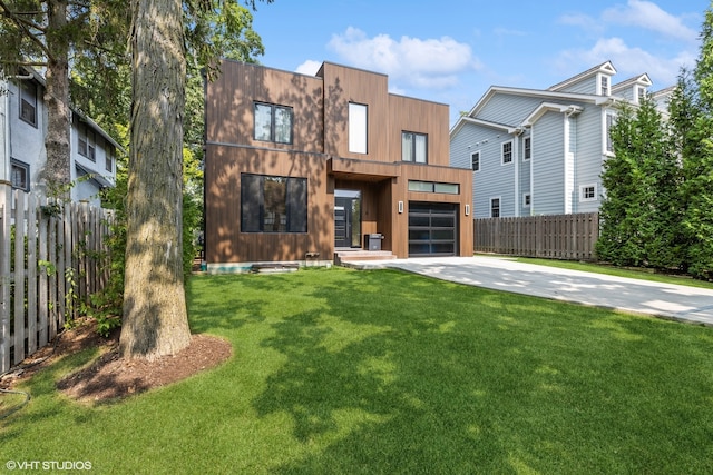 back of house featuring a garage and a lawn