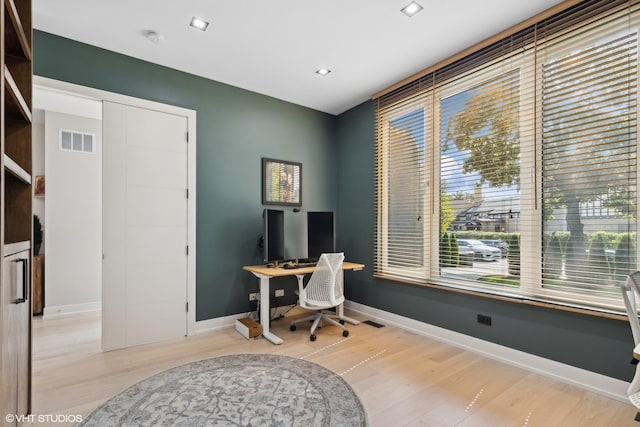 home office featuring visible vents, baseboards, and wood finished floors