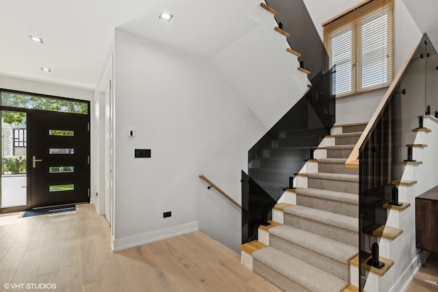 foyer featuring light wood finished floors, stairway, recessed lighting, and baseboards