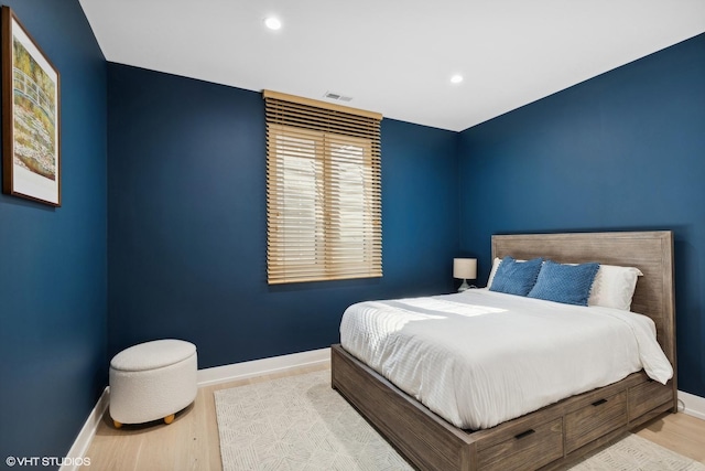 bedroom featuring visible vents, baseboards, and wood finished floors