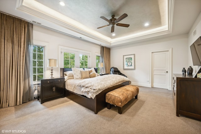 bedroom featuring a raised ceiling, ceiling fan, ornamental molding, and light carpet