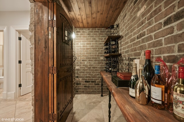 wine room featuring brick wall and wooden ceiling