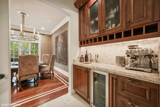 bar with hanging light fixtures, light wood-type flooring, sink, wine cooler, and ornamental molding