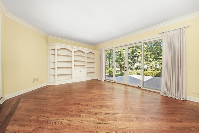 unfurnished living room featuring hardwood / wood-style flooring, ornamental molding, built in features, and french doors