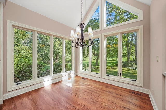 unfurnished sunroom featuring a notable chandelier and vaulted ceiling