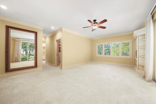 carpeted empty room with crown molding, ceiling fan, and plenty of natural light