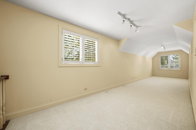 additional living space with lofted ceiling and light carpet