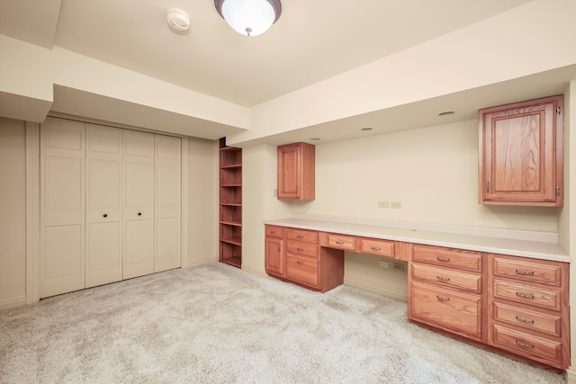 unfurnished office with built in desk and light colored carpet