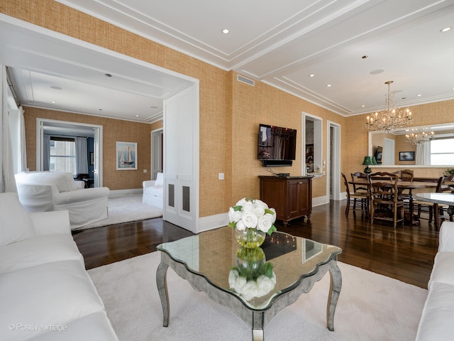 living room with ornamental molding, a chandelier, and dark wood-type flooring