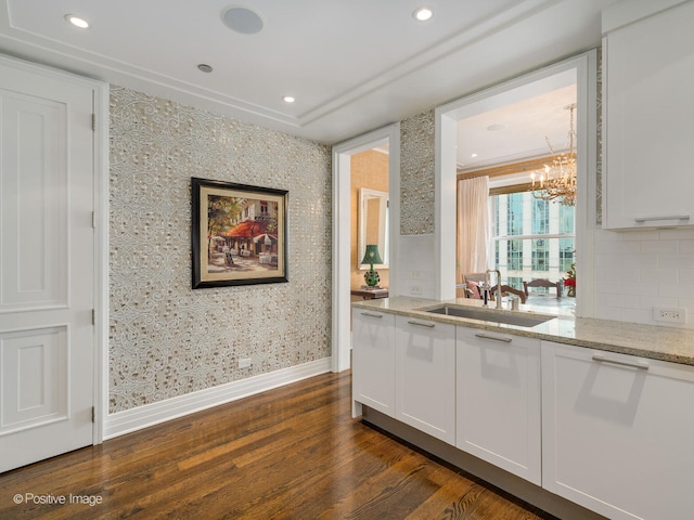 kitchen featuring an inviting chandelier, white cabinetry, sink, and dark wood-type flooring