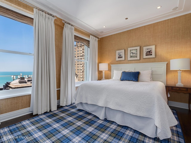 bedroom with a water view, crown molding, and dark hardwood / wood-style flooring