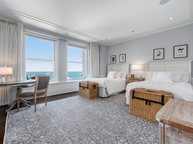 bedroom featuring ornamental molding, a water view, and hardwood / wood-style flooring