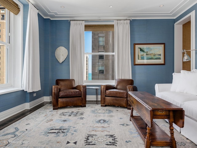 living area featuring wood-type flooring and crown molding