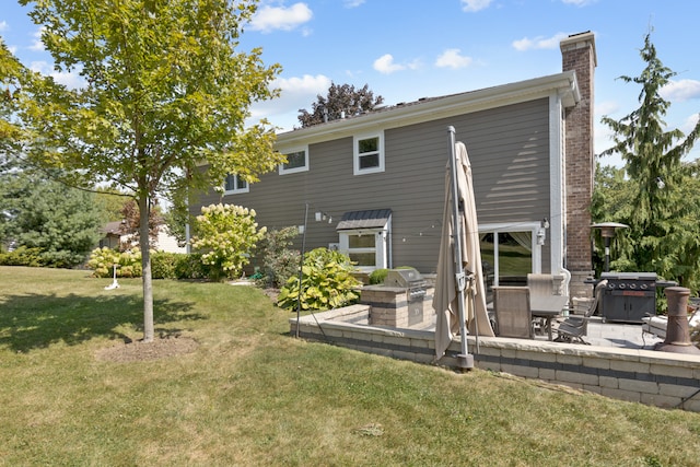 rear view of property featuring a yard and a patio