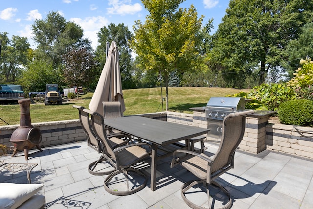 view of patio featuring an outdoor kitchen and a grill