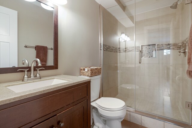 bathroom featuring walk in shower, vanity, and toilet