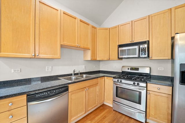 kitchen with light wood-type flooring, sink, lofted ceiling, appliances with stainless steel finishes, and light brown cabinetry