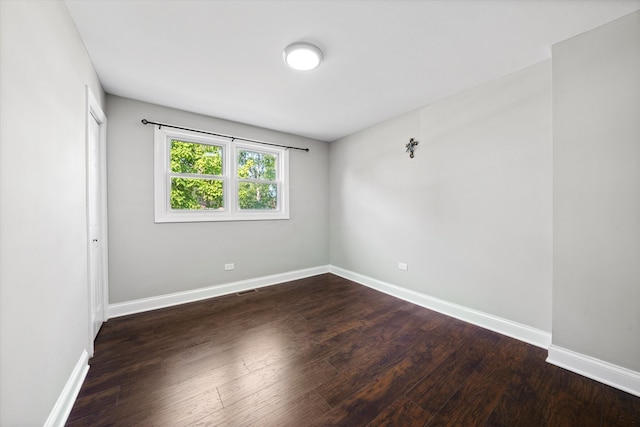 spare room with dark wood-type flooring