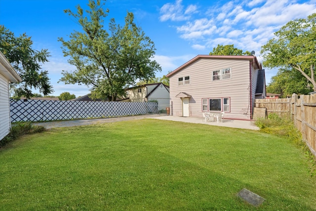 back of property with a yard and a patio area