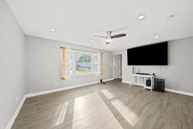 unfurnished living room featuring ceiling fan and hardwood / wood-style flooring